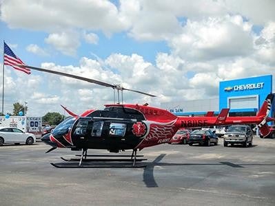 Red helicopter parked outside Chevrolet dealership