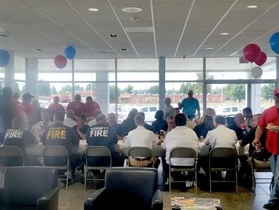 Team of Glen Sain Chevrolet, Kennett seated on chairs, dressed in red, black, white, and blue outfits